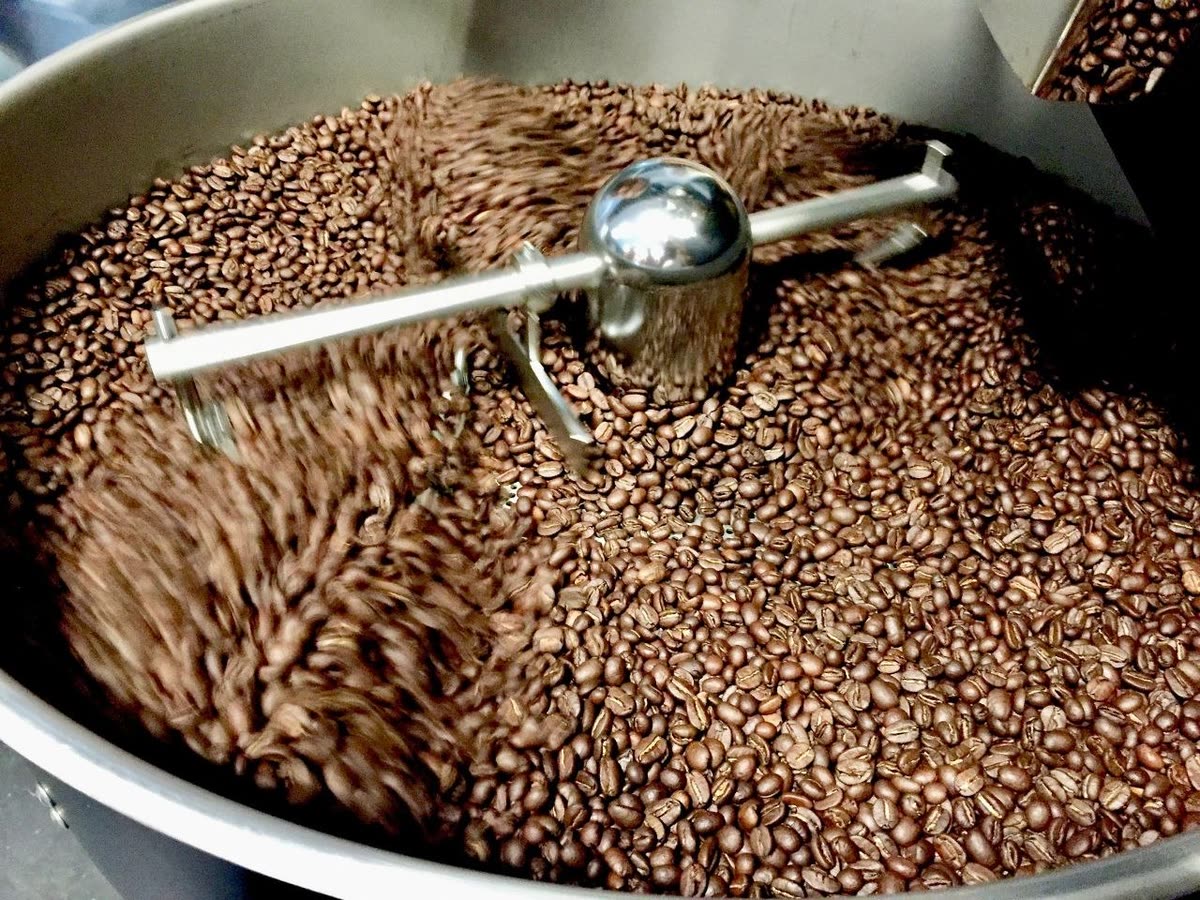 Granos de café recién tostados girando en el enfriador